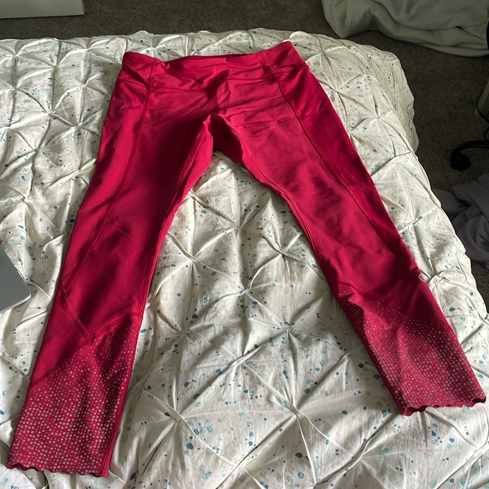 Red Lululemon leggings with silver polka dot ankles.